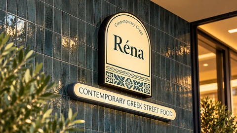 Illuminated Réna sign on a dark tiled wall